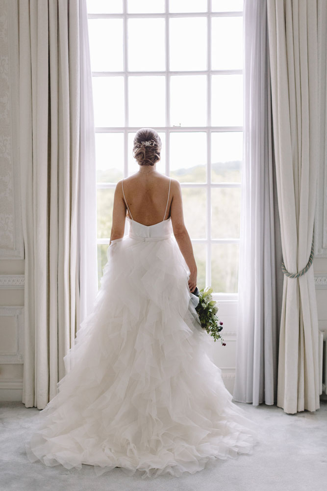 Bride standing by window, hair by Alice